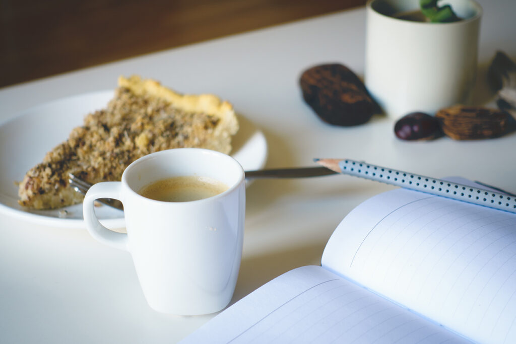 empty pages and pencil with a cup of coffee and pie