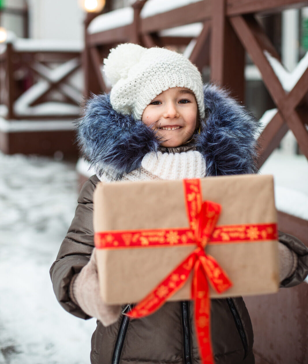 child dressed for winter with a Christmas gift