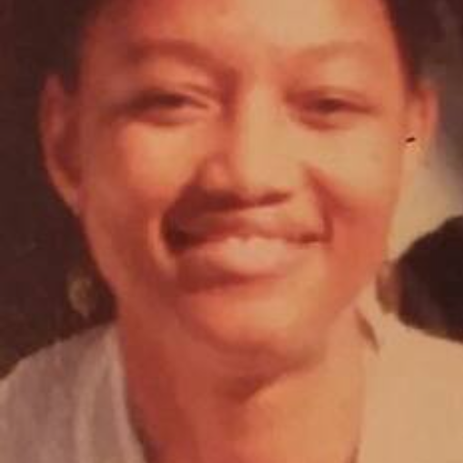 Photo of Dr. Genuyah Reuven, a young African American woman in a white coat, smiling