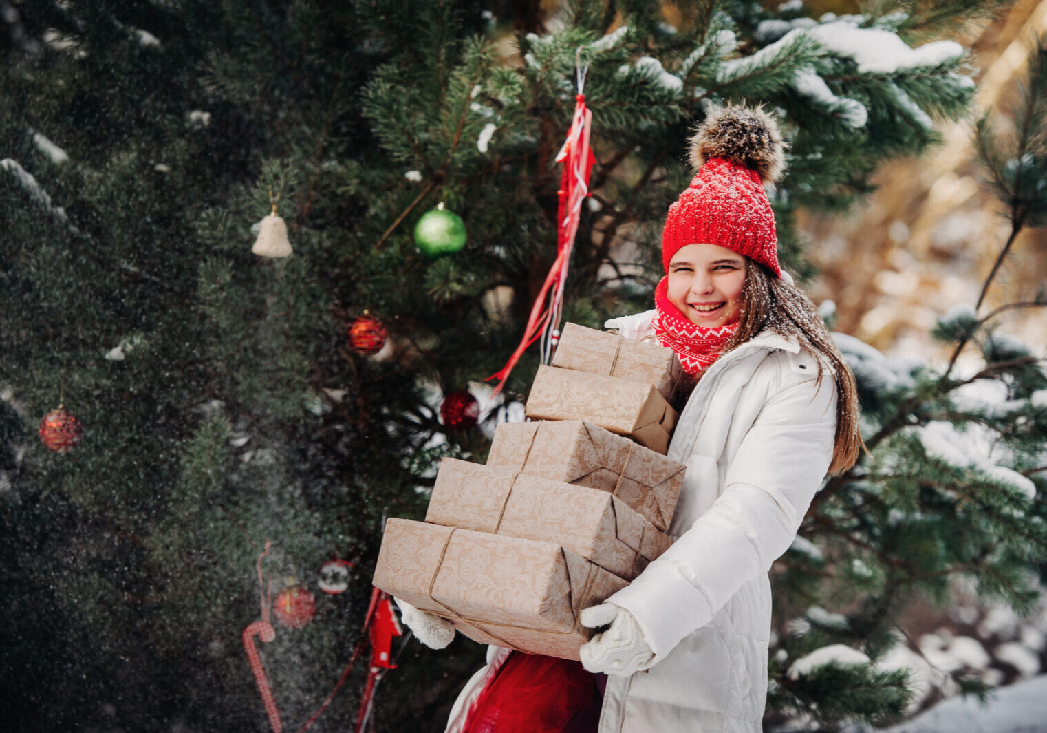 child dressed for winter with multiple Christmas gift