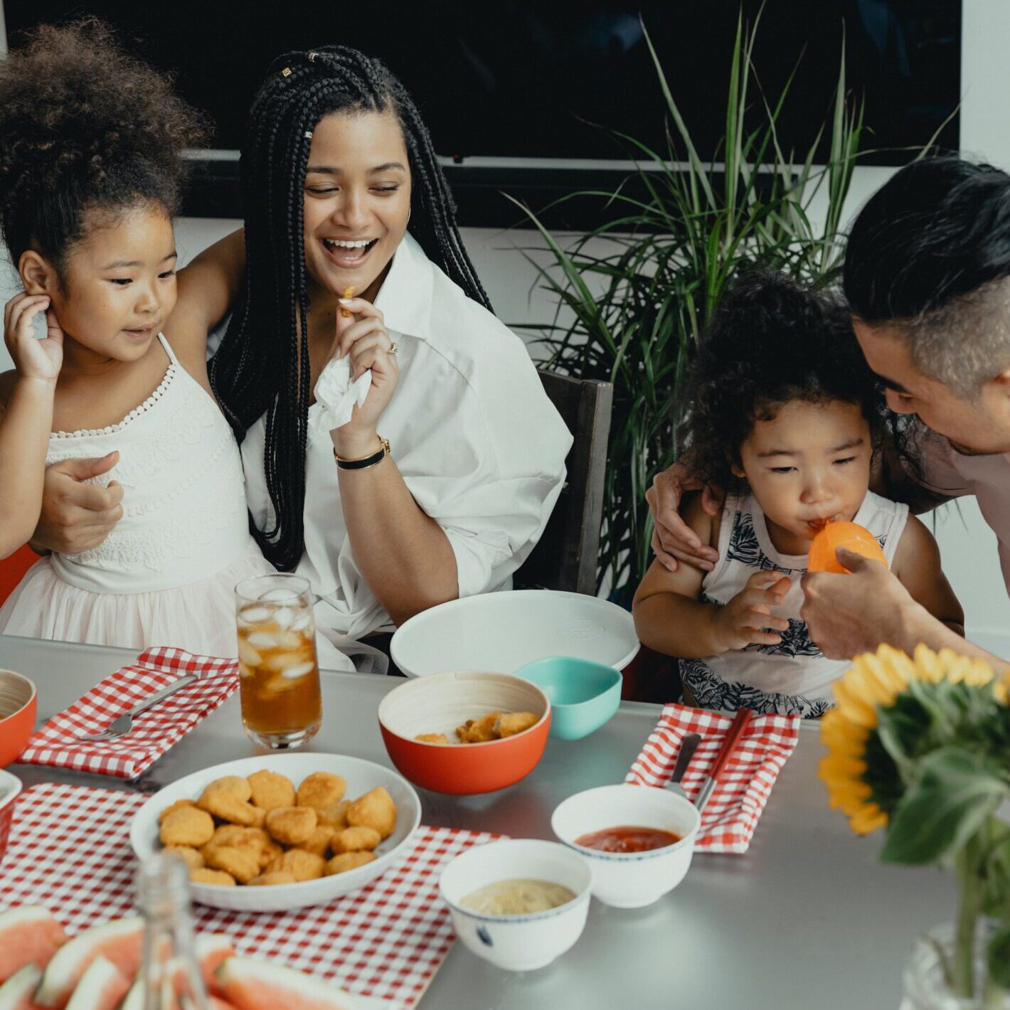 diverse Family of black and asian parents having dinner with their two young girls